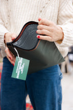 Petite glacière souple de couleur vert foncé, fermé par une fermeture éclair bordée d’une couture orange.